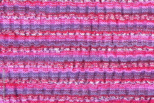 Abstract knitted colorful background. Wave pattern of pink, blue, yellow, purple knitting threads. Close-up of a knitted blanket. Copy space