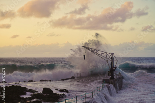 Dock and crane in the fishing village of El Pris, at sunset on a day of strong waves (Tacoronte, Tenerife) photo