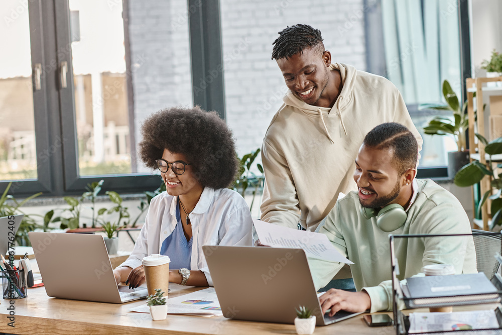 three happy young african american friends working cheerfully on their project, business concept three happy young african american friends working cheerfully on their project, business concept
