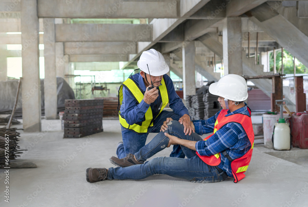 a worker's legs was injured at site, a colleague rescued him from accident and using walkie-talkie to call first aid team.concept risk management, safety at work,accident in site work a worker's legs was injured at site, a colleague rescued him from accident and using walkie-talkie to call first aid team.concept risk management, safety at work,accident in site work