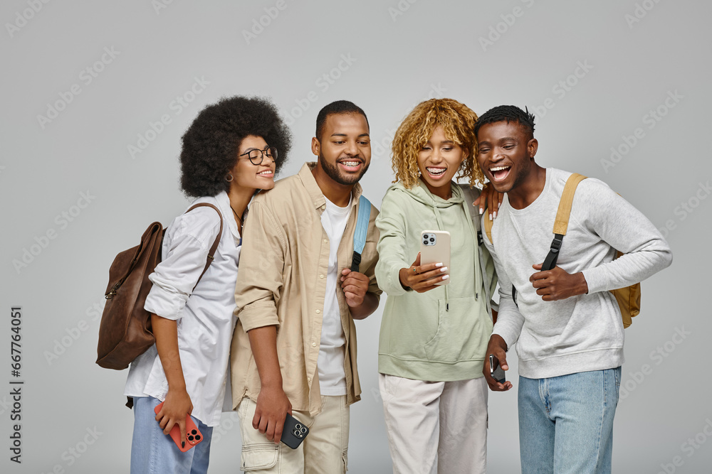 good looking friends in casual outfits with backpacks looking at phone smiling happily, students good looking friends in casual outfits with backpacks looking at phone smiling happily, students