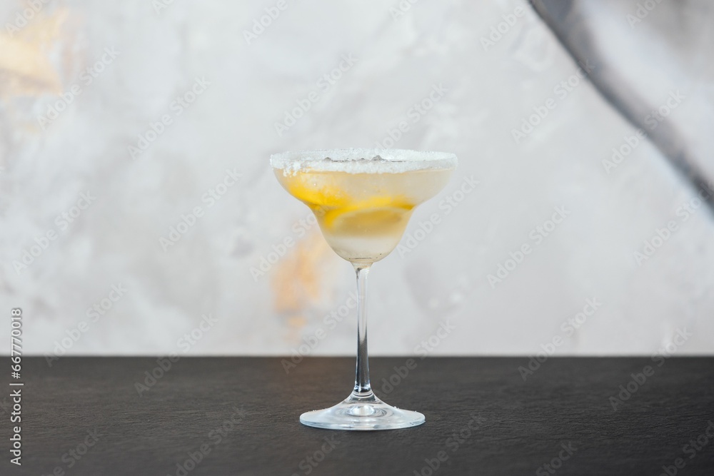Fototapeta premium a margarita cocktail on a table with lemon slices around the rim