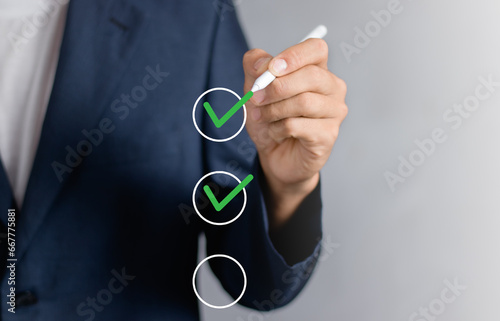 Checklist concept, Businessman checking mark on the check boxes with marker red.