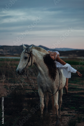 Portrait of a white horse and sexy woman. Beautiful glamour woman with a horse. Portrait of a beauty undressed woman with horse.