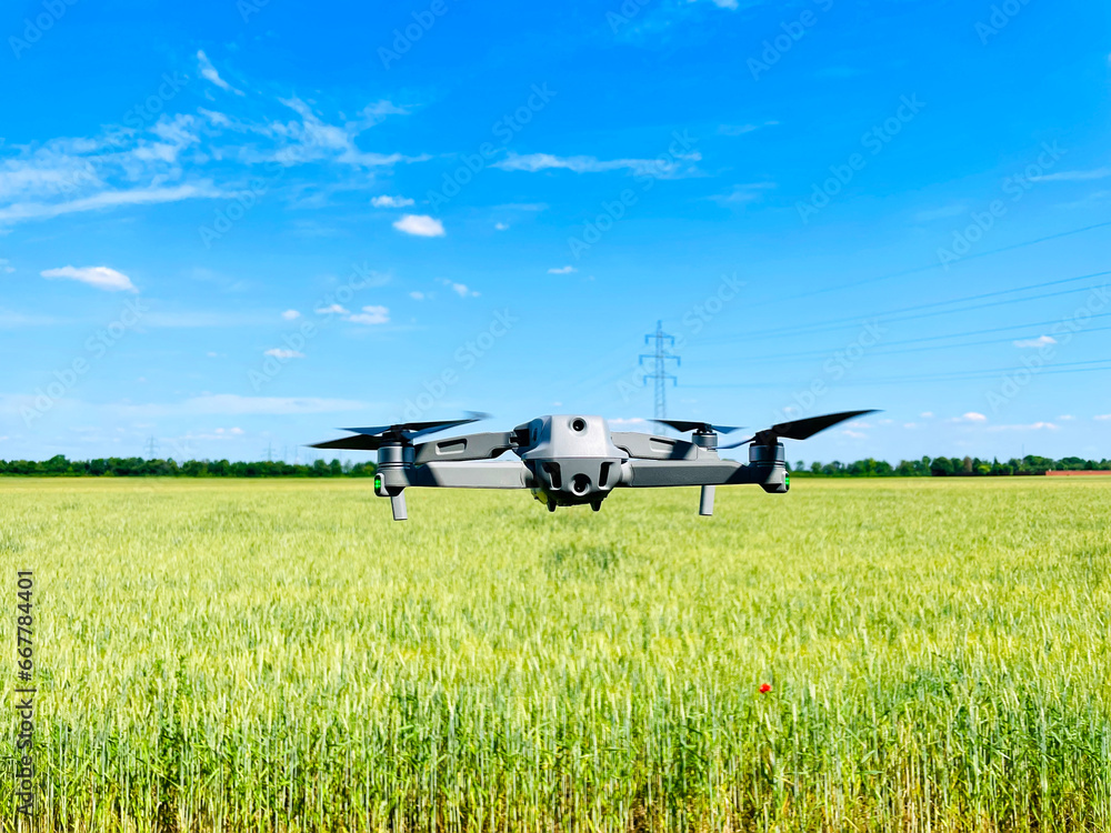 Drone hovering above wheat field, concept of using Drones in agriculture Drone hovering above wheat field, concept of using Drones in agriculture