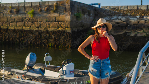 serious young girl looking at the camera with a motor boat zodiac