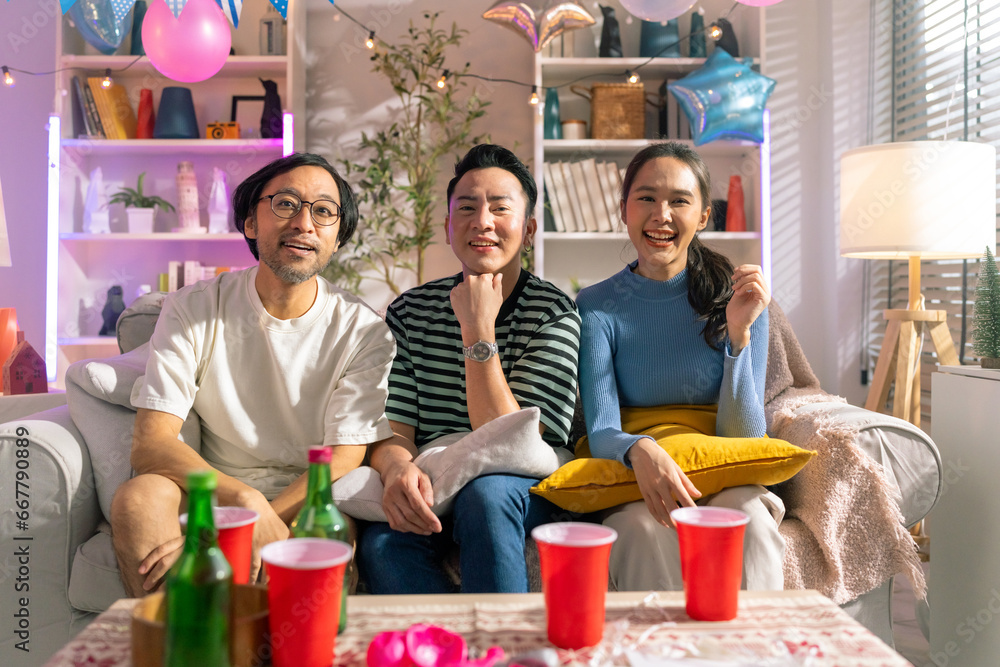 Obraz premium portrait shot of fun and playful laugh cheering joyful together in christmas and new year party on sofa couch at home fun photo group shot friend in home party