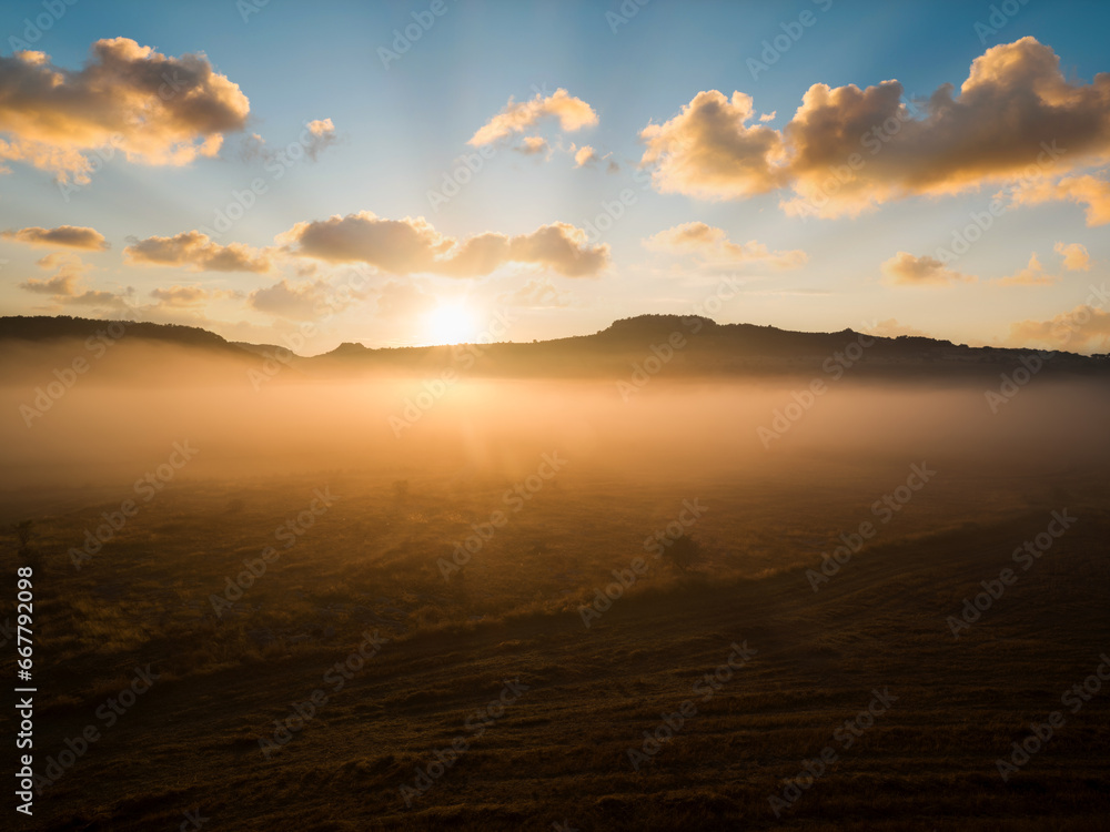 Dry fields at sunrise. Dramatic sunrise in foggy fields