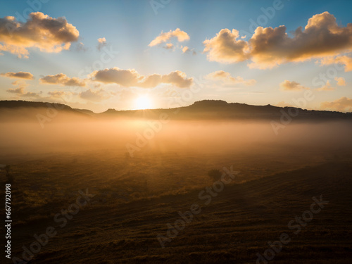 Dry fields at sunrise. Dramatic sunrise in foggy fields