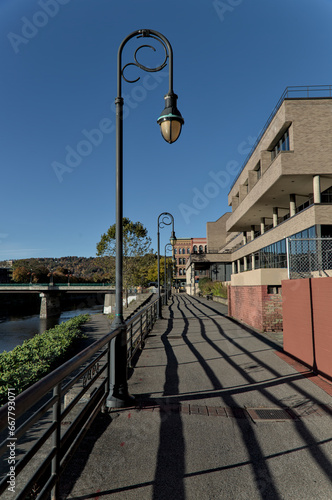 view of court street with streetlight from binghamton river walk pedestrian path along chenango (downtown historic district with urban architecture, buildings, street lamp) city park photo