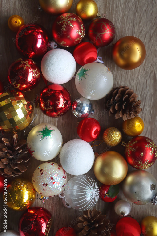 Pine cones and red, golden and white Christmas ornaments on wooden background. Top view. Pine cones and red, golden and white Christmas ornaments on wooden background. Top view.