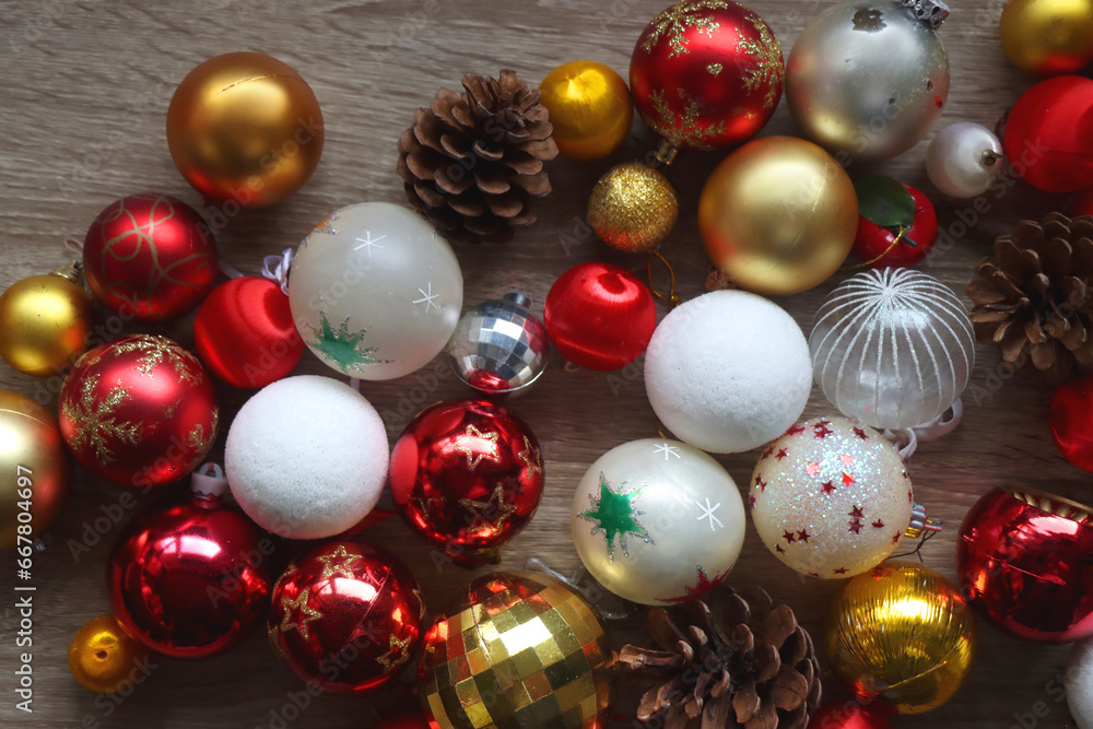Pine cones and red, golden and white Christmas ornaments on wooden background. Top view. Pine cones and red, golden and white Christmas ornaments on wooden background. Top view.