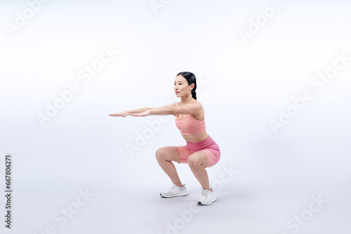 Fototapeta Naklejka Na Ścianę i Meble -  Vigorous energetic woman doing exercise. Young athletic asian woman strength and endurance training session as squat workout routine session. Full body studio shot on isolated background.