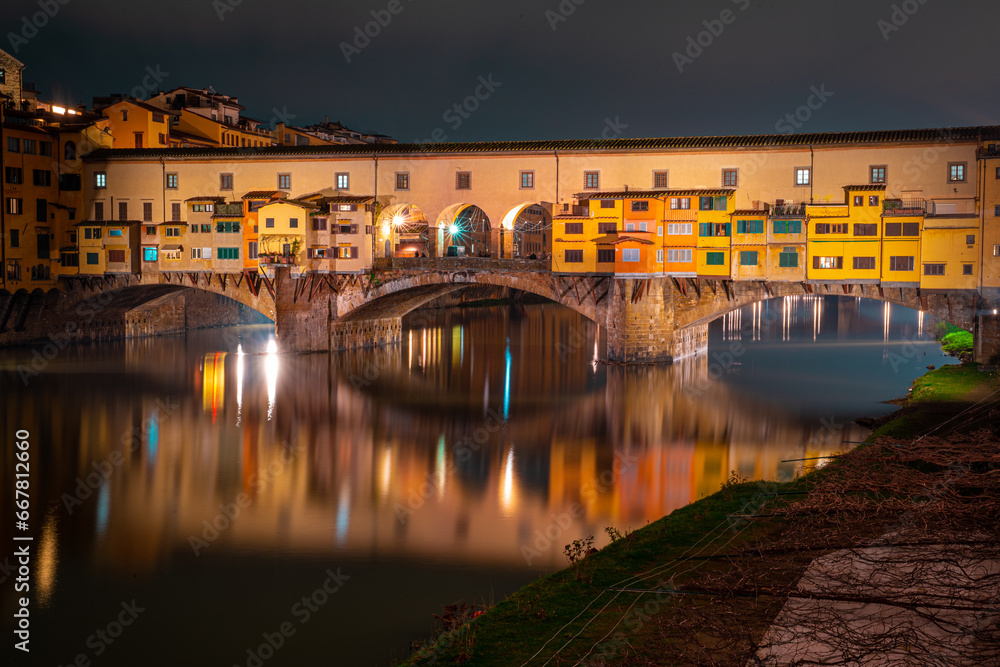Obraz premium The Ponte Vecchio in Florence, Italy, at night with the reflection of the bridge and lights in the river