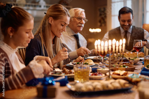 Happy Jewish woman enjoys in meal with her family on Hanukkah.