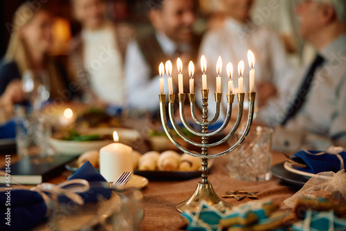 Εκτύπωση καμβά Lit candles in menorah with extended Jewish family in background on Hanukkah