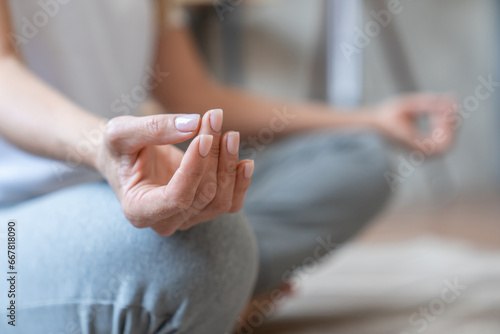 Foto Closeup nails female hands serene mature woman athlete yogi meditating in lotus position with eyes closed at home