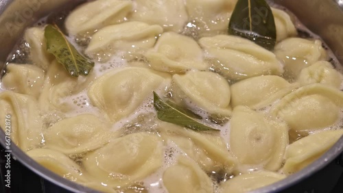 pelmeni, dumplings are boiled in boiling water with bay leaf