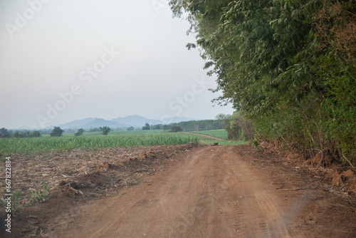 Country road down from the hill, mountain far away ahead, Thailand.