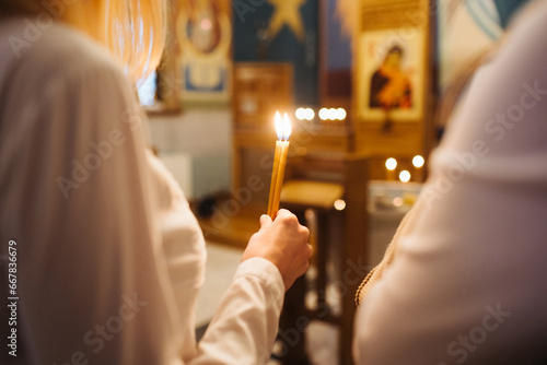 Orthodox church candle background. Hand holding candle during ceremony. Baptism ceremony in East of Europe. photo