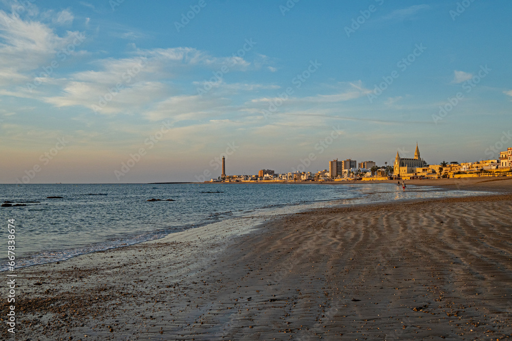Regla beach with church and lighthouse in Chipiona in warm evening light