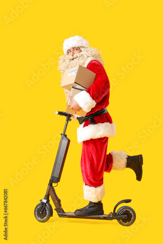 Santa Claus with parcels rides electric scooter on yellow background