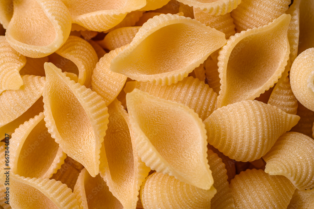 Raw Italian pasta conchiglie from durum wheat with vegetables, salt and spices Raw Italian pasta conchiglie from durum wheat with vegetables, salt and spices