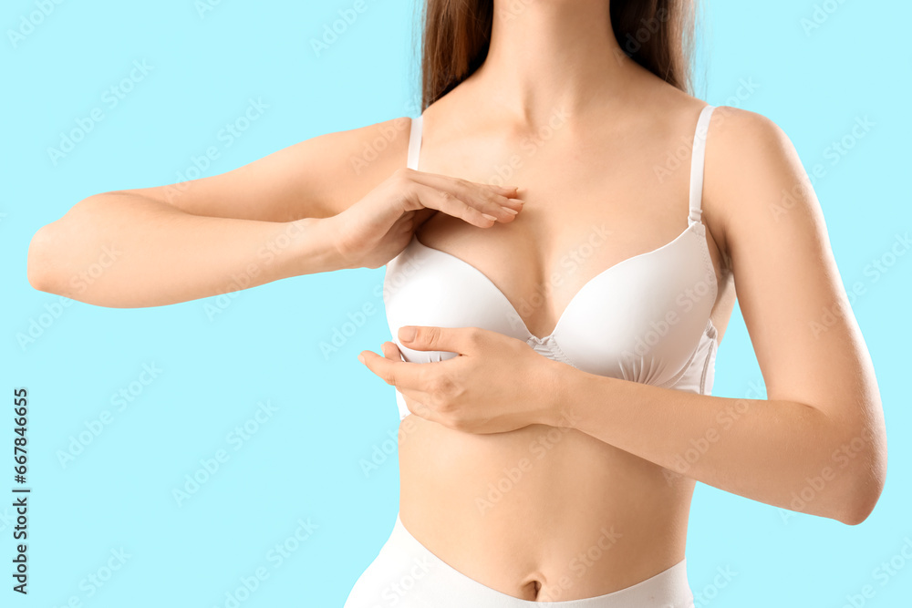 Young woman in bra on blue background