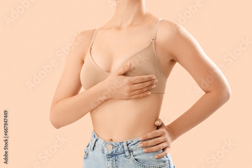 Young woman in bra on beige...
