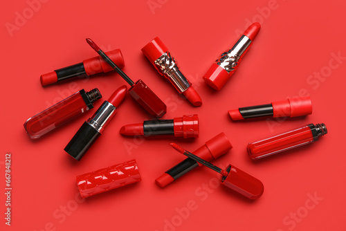 Different stylish new lipsticks on red background