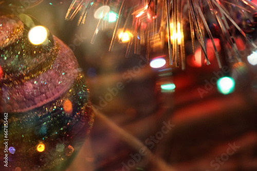 the photo shows a bright, colorful Christmas tree toy in the glare of Christmas tree colored garlands, an atmosphere of joy