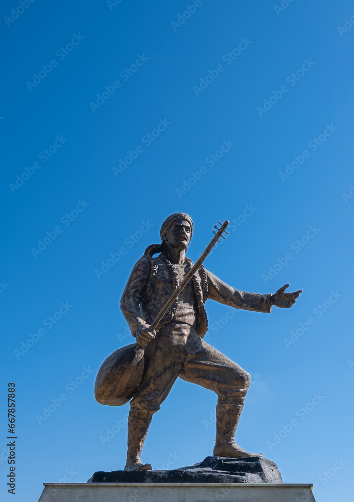 Fototapeta premium Karacaoglan statue in Adana. Turkey. Blue sky background.