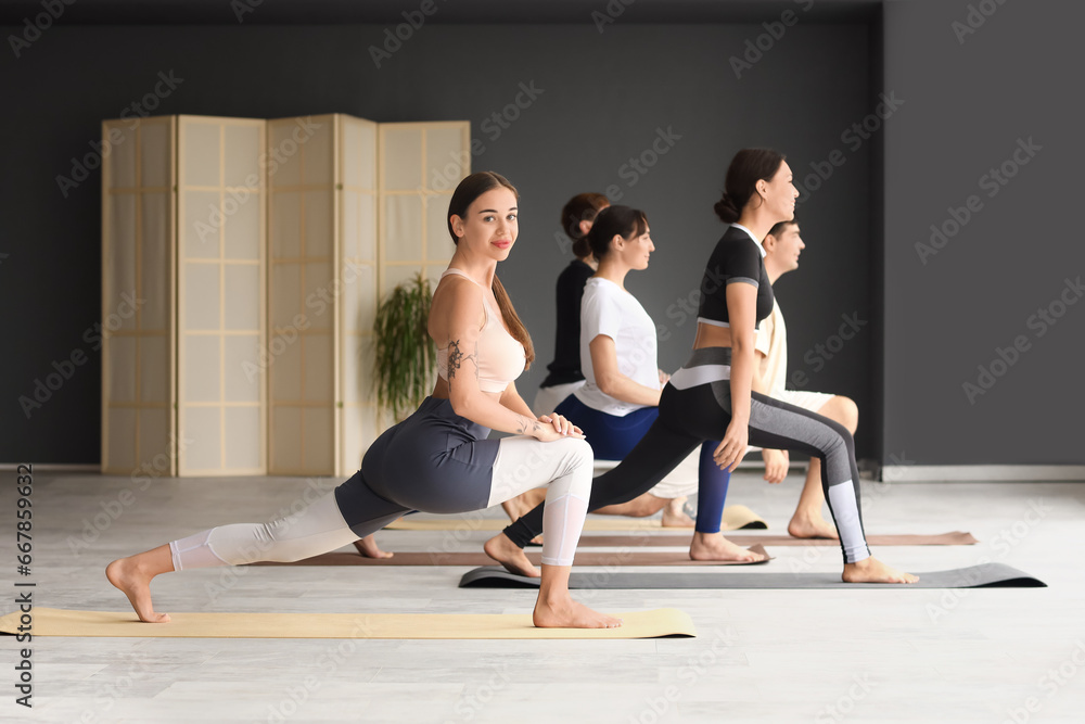 Group of sporty young people practicing yoga in gym Group of sporty young people practicing yoga in gym