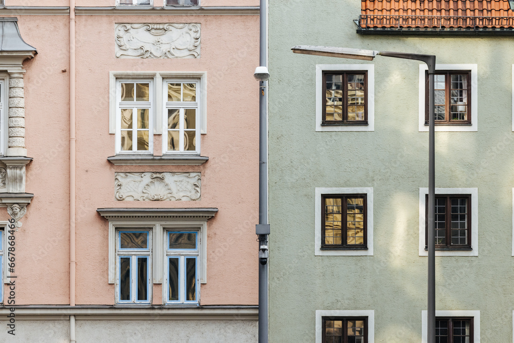 A pink and a green house facade of an old buildings in Munich, Germany