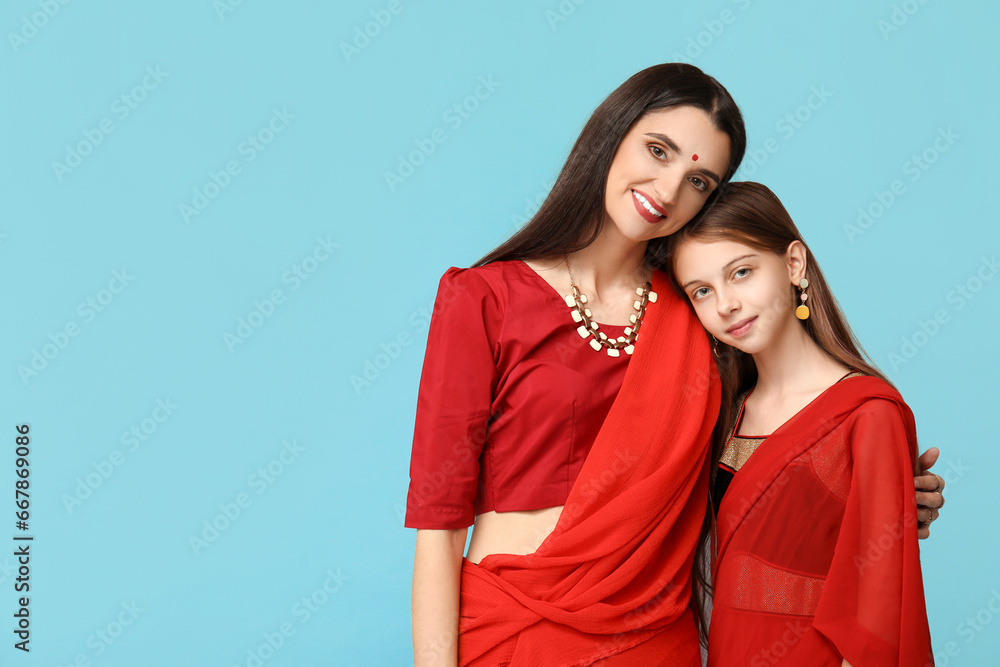 Mother with her daughter in sari on blue background. Divaly celebration Mother with her daughter in sari on blue background. Divaly celebration