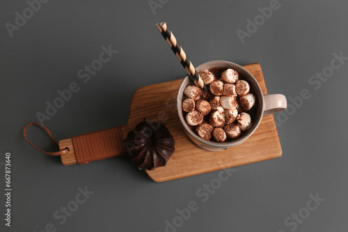 Cup of hot cocoa with marshmallows on grey background