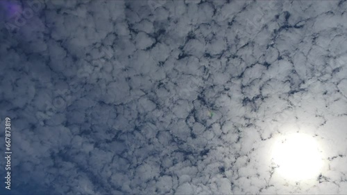 Blue sky with sun and moving Cirrocumulus clouds - timelapse. Topics: texture of clouds, weather, meteorology photo