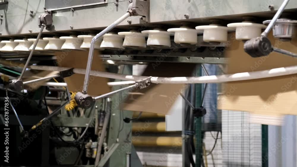 Conveyor line for the production of boxes. Machine carves cardboard boxes from sheets of cardboard. Enterprise for the production containers . Conveyor line for the production of boxes. Machine carves cardboard boxes from sheets of cardboard. Enterprise for the production containers .
