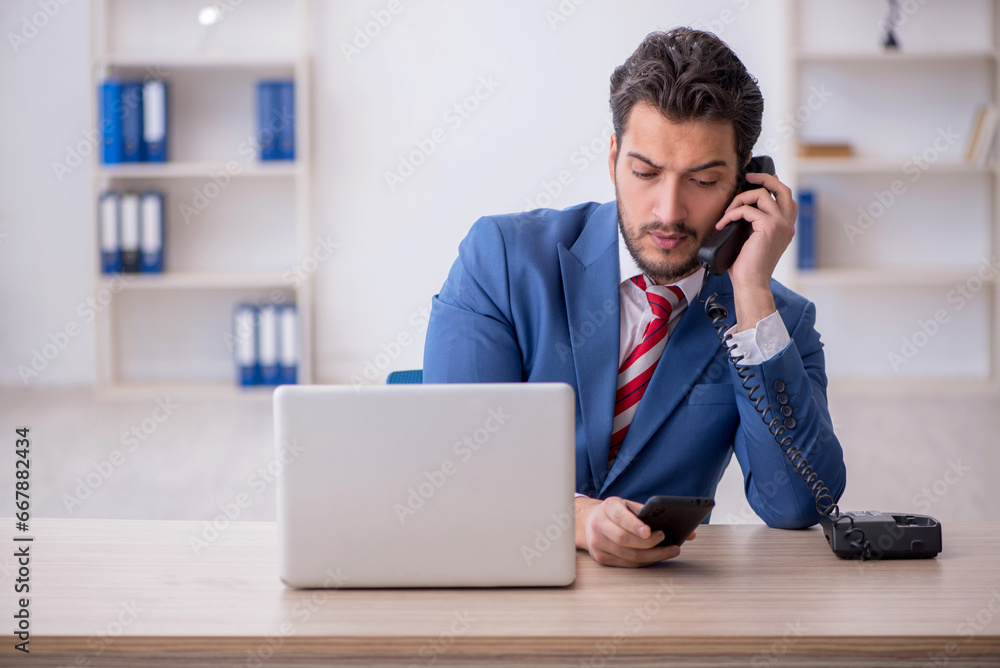 Young male employee working in the office Young male employee working in the office