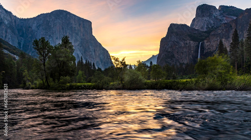 dramatic sunrise in Yosemite National park with the Merced River on the foreground and Bridal Veil Falls and The El Capitan on the background. photo