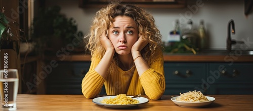 Unhappy white woman avoids eating homemade pasta due to diet photo