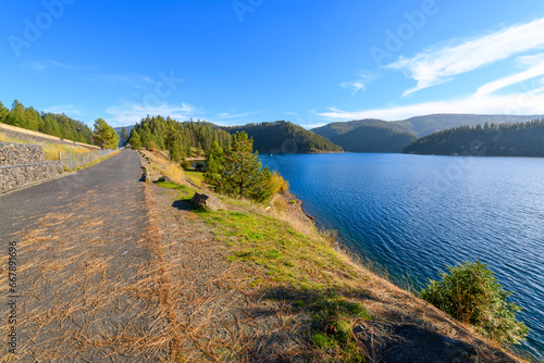 The lakefront walking centennial trail at the Coeur d'Alene Parkway State Park at Higgens Point on the lake at autumn, in Coeur d'Alene, Idaho USA.