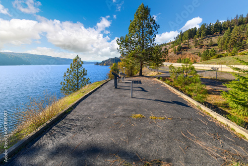 The Photographer Statue of Leopold with camera at the lakefront walking centennial trail at the Coeur d'Alene Parkway State Park at Higgens Point on the lake at autumn, in Coeur d'Alene, Idaho USA. photo