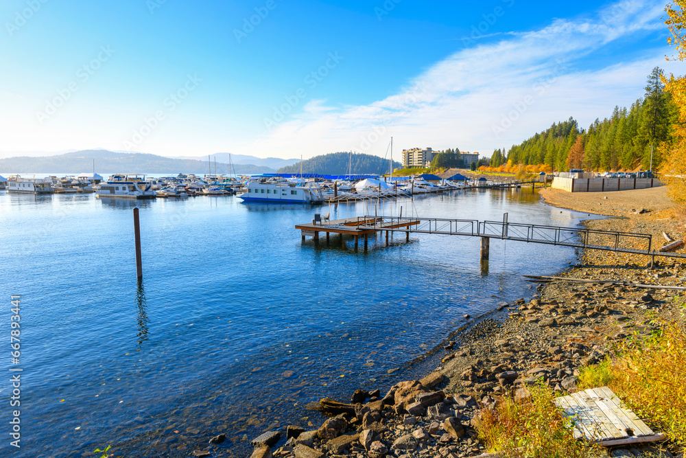 The Silver Beach marina with Tubbs Hill and upscale condominiums in view behind with fall colors on the trees at Lake Coeur d'Alene, Idaho.