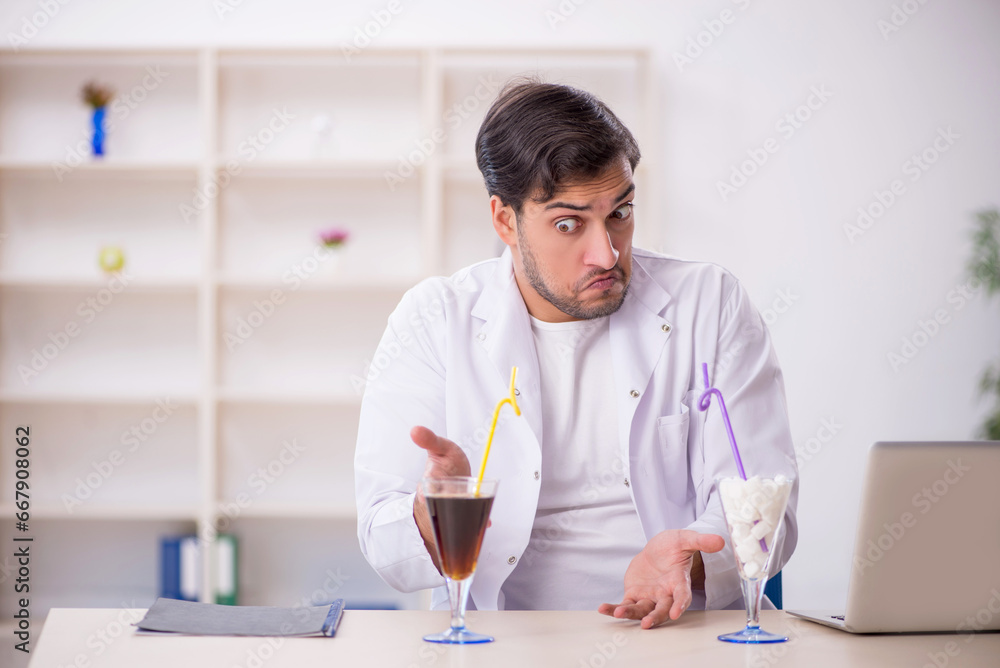 Young male chemist examining soft drink at the lab Young male chemist examining soft drink at the lab