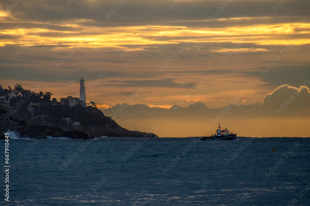 La presqu'île du Cap Ferrat avec son phare près de Nice sur la Côte d'Azur dans les lueurs oranges d'un lever de soleil.