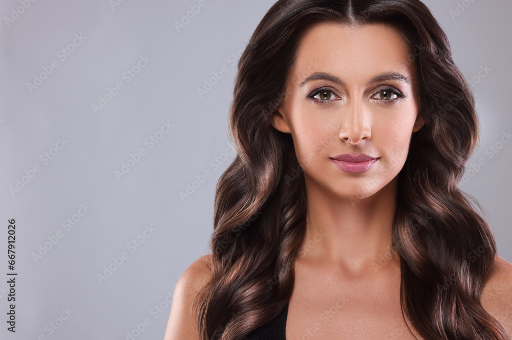 Gorgeous woman with shiny wavy hair on grey background, space for text. Professional hairstyling Gorgeous woman with shiny wavy hair on grey background, space for text. Professional hairstyling