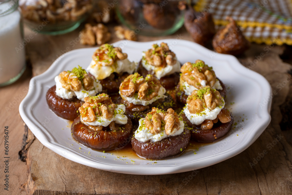 Stuffed dry fig dessert, cooked with syrup, traditional, pistachio and kaymak (Turkish name; kaymakli incir tatlisi )