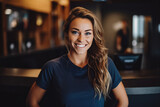 Beautiful athletic caucasian female gym owner standing behind reception and smiling, business woman owner at work place