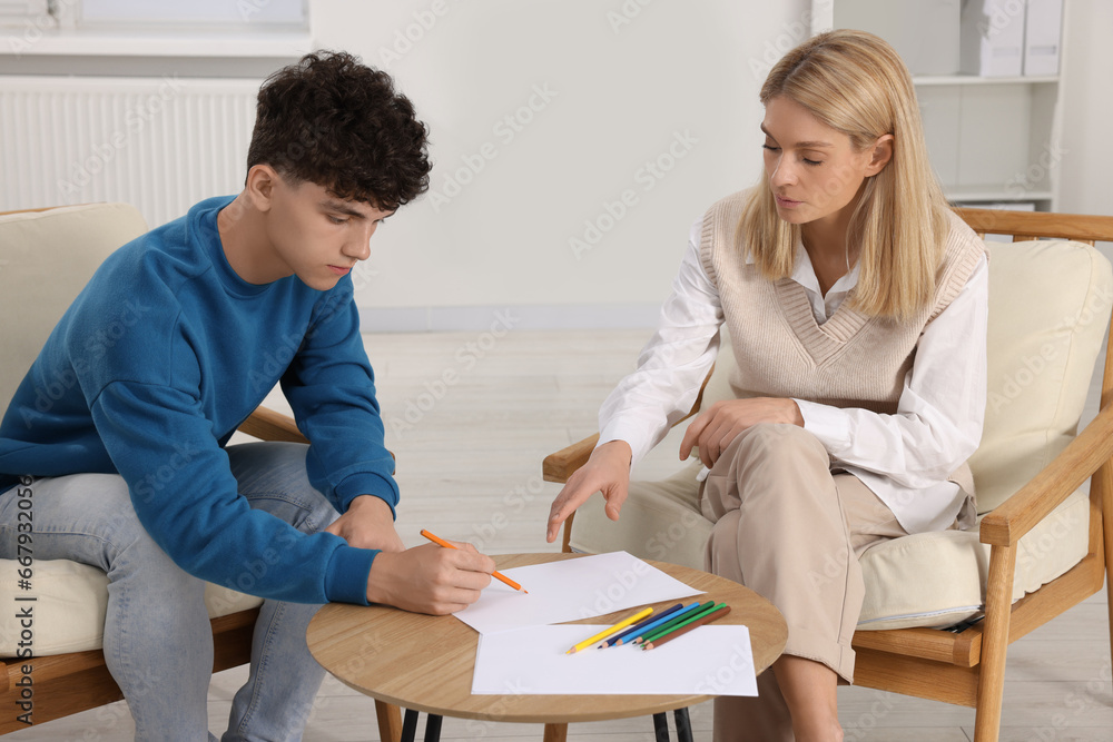 Obraz premium Psychologist working with teenage boy in office. Teenager problems